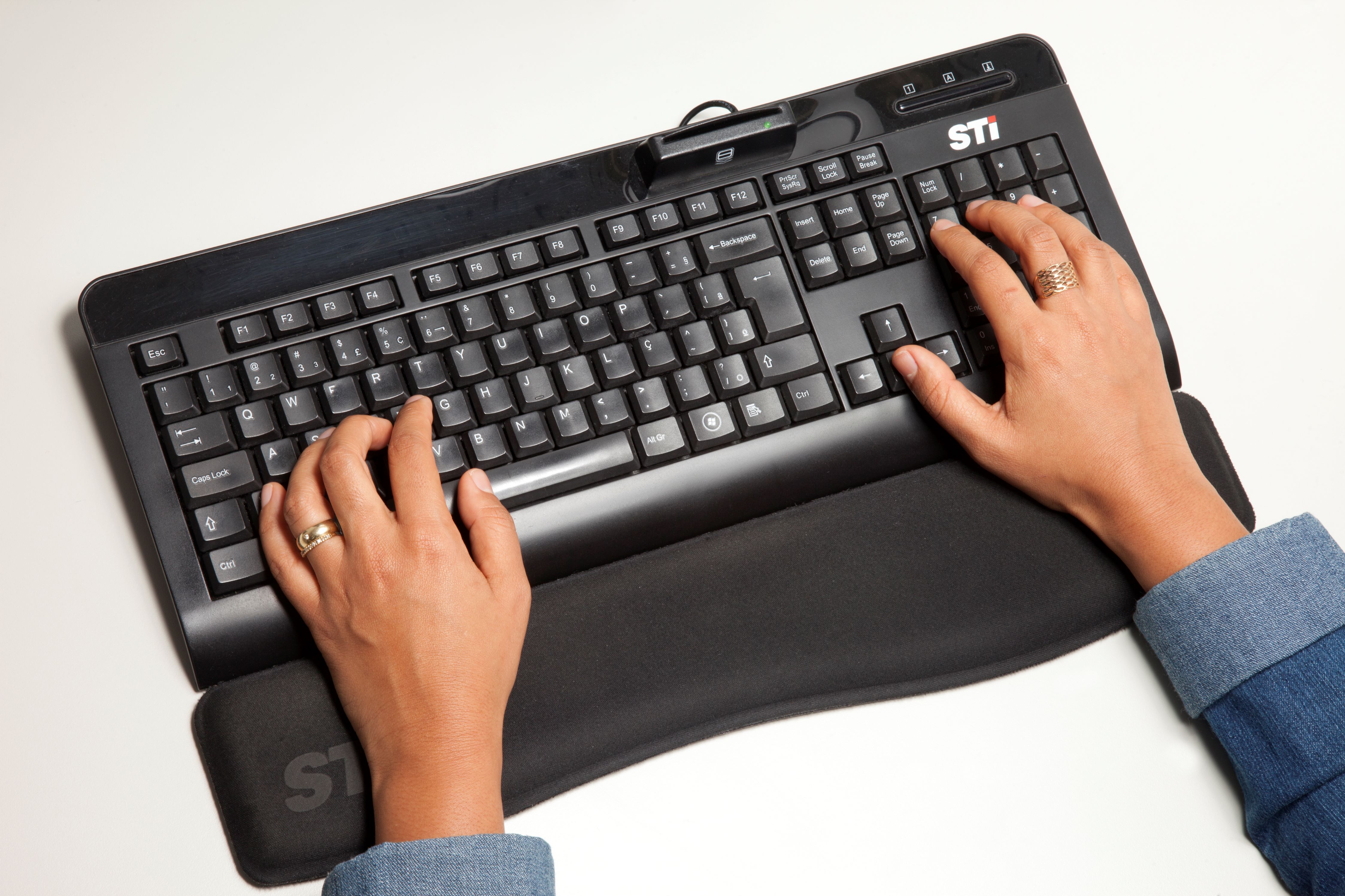 Mãos digitando um teclado sobre um fundo branco