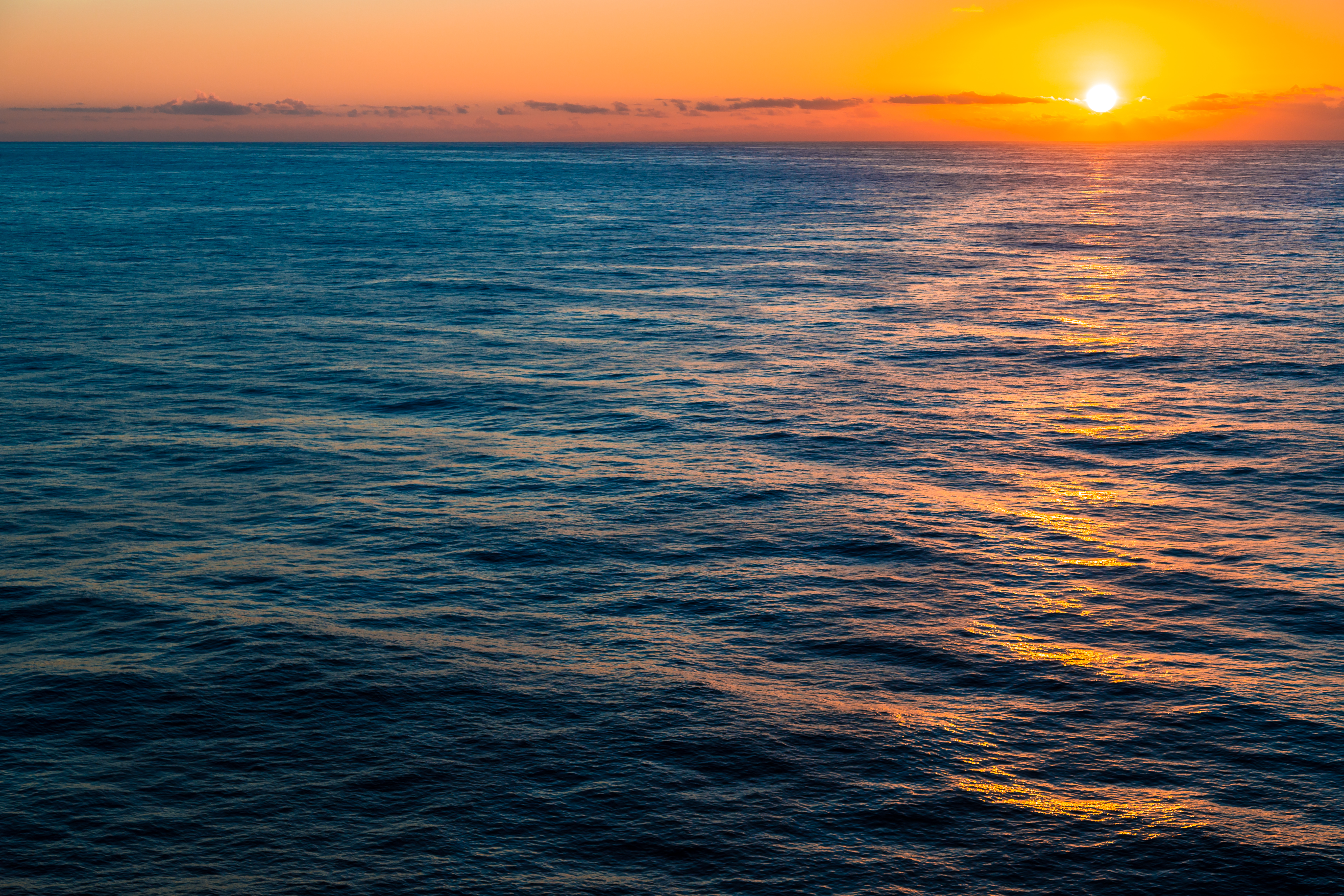 Mar do Oceano Atlântico com por do sol ao fundo, no horizonte