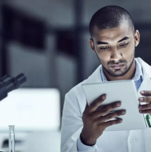 Estagiário da Petrobras em um laboratório, com um tablet em mãos.