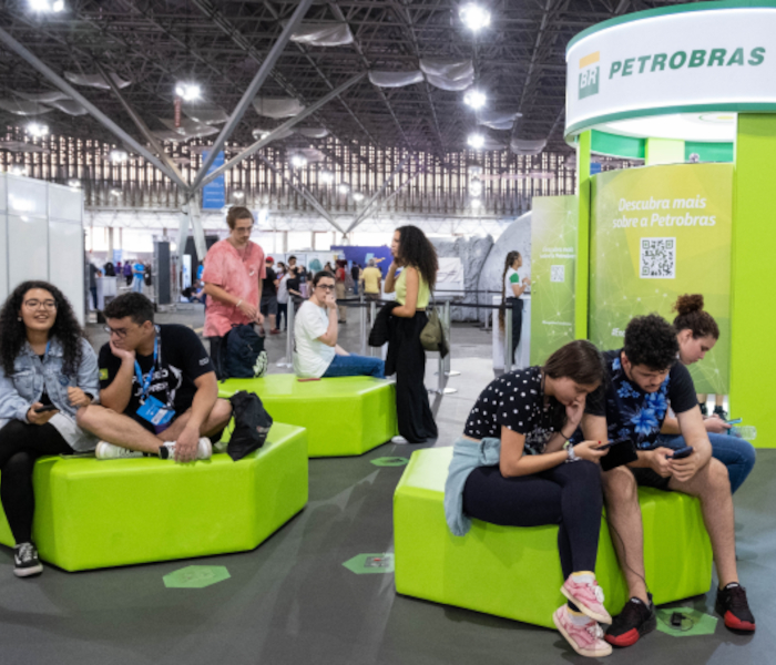 Fotografia de stand da Petrobras em um evento, com diversas pessoas interagindo entre si.