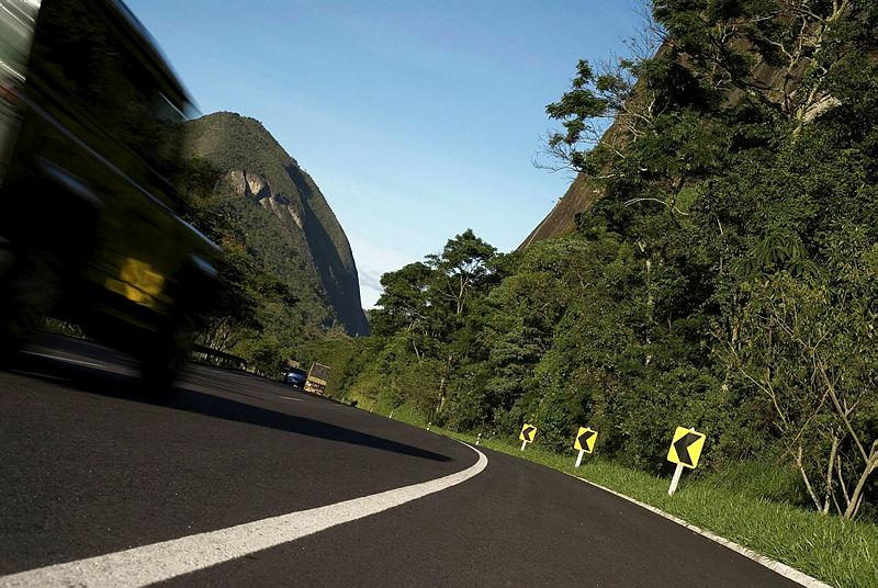 Fotografia de carro andando em asfalto. A imagem representa uma estrada.