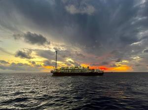 Foto de navio-plataforma no meio do oceano ao entardecer